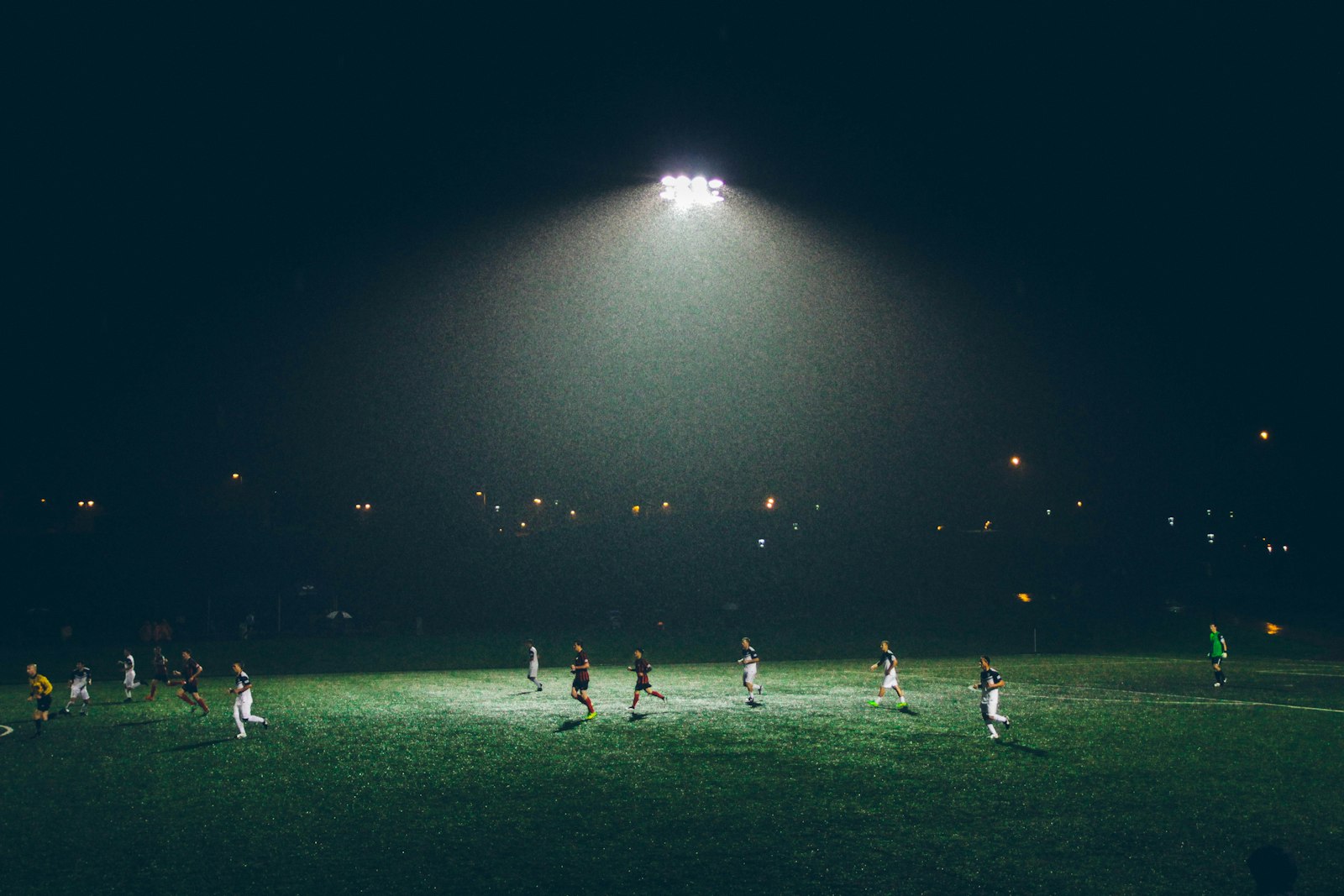 Football players competing under stadium lights